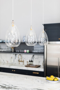 Clear Wellington pendant lights over a kitchen island