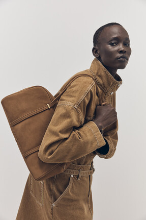 Tu-AW26-Model-07 - Tobacco Denim Funnel-Neck Trucker Jacket £32 Tobacco Denim Co-ord Mini Skirt £20 Heritage Tan Suede Bowler Bag £38
